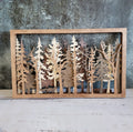 Wooden wall art with tree cutouts on a textured surface
